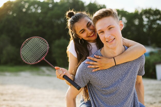 Plano medio pareja feliz con raqueta de bádminton