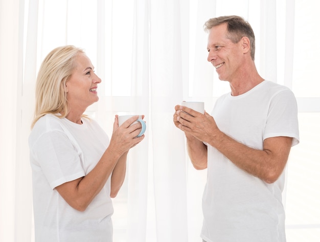 Foto gratuita plano medio pareja feliz con tazas