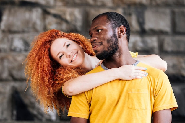 Plano medio de pareja interracial sonriendo