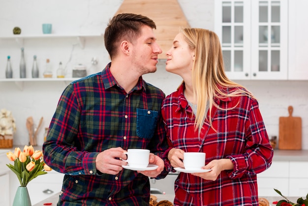 Foto gratuita plano medio pareja lista para besarse en la cocina