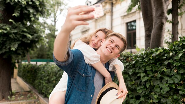 Plano medio pareja tomando selfie