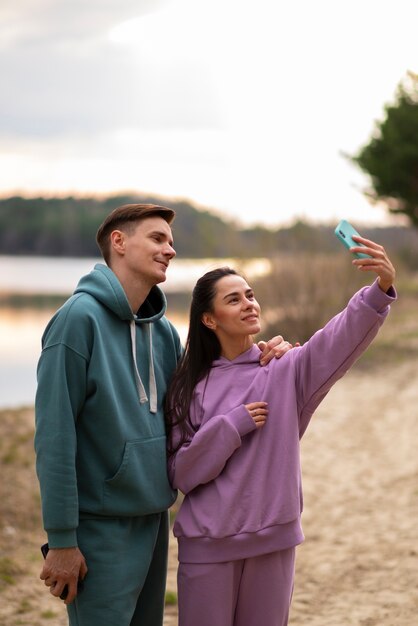 Plano medio pareja tomando selfie