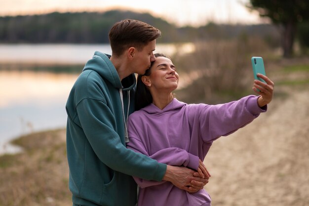 Plano medio pareja tomando selfie