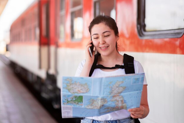 Foto gratuita plano medio sonriente mujer sosteniendo mapa