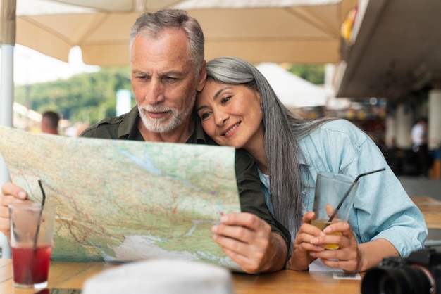 Plano medio sonriente pareja sosteniendo mapa