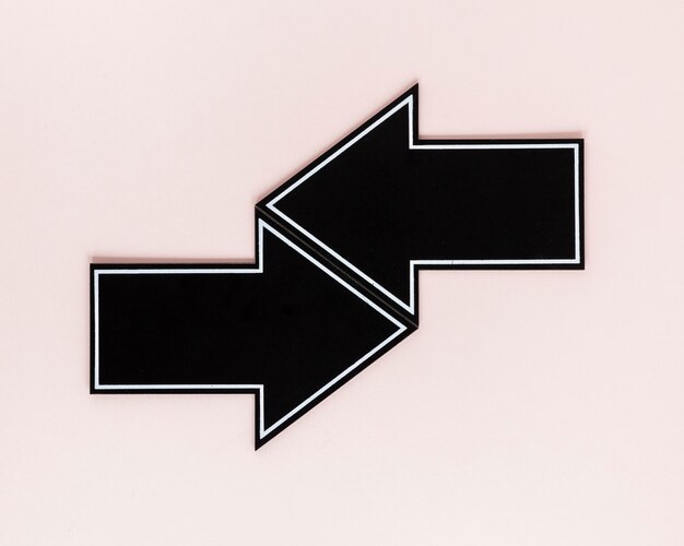 Plano pone flechas negras sobre fondo rosa