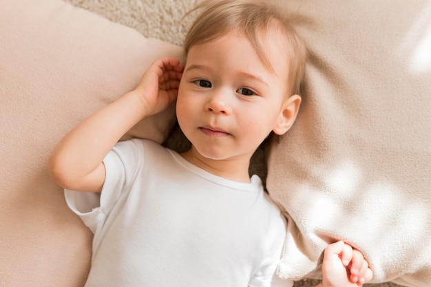 Plano pone lindo bebé sobre almohadas