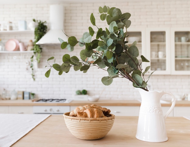 Planta decorativa sobre mesa en luminosa cocina moderna.