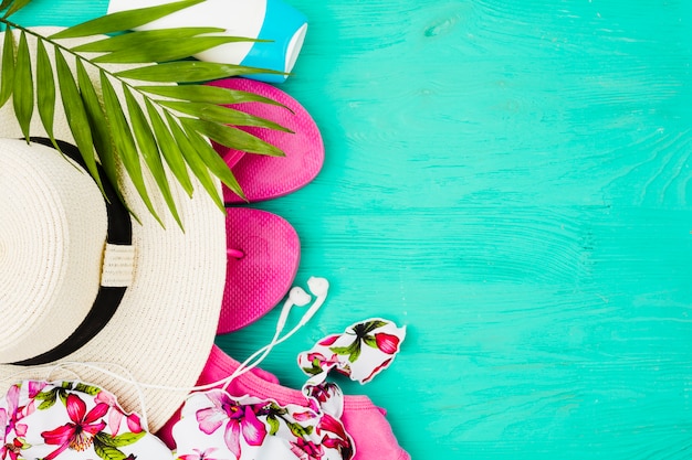 Foto gratuita planta de follaje y traje de baño cerca de chanclas y sombrero.