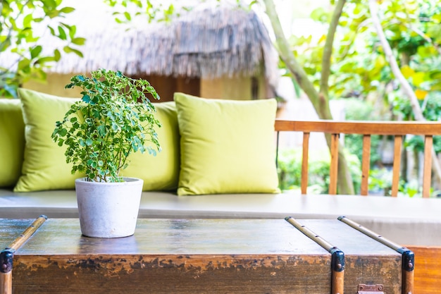 Planta de jarrón sobre decoración de mesa con almohada en sillón