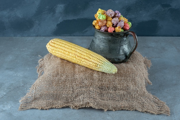 Planta de maíz y palomitas de maíz con sabor colorido en una olla metálica. Foto de alta calidad