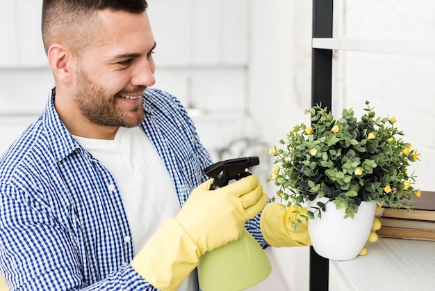 Foto gratuita planta de riego de hombre sonriente