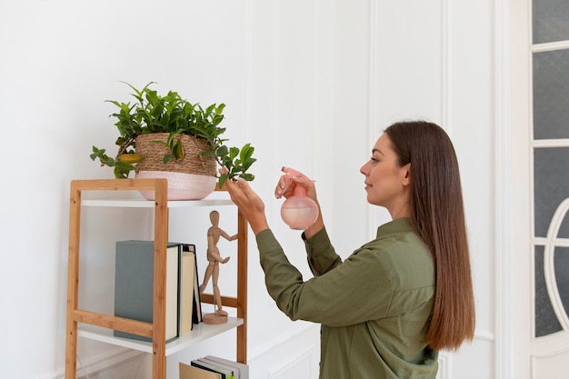 Foto gratuita planta de riego de mujer de tiro medio