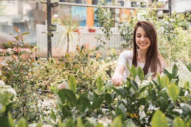 Foto gratuita plantas de examen de la mujer feliz en invernadero