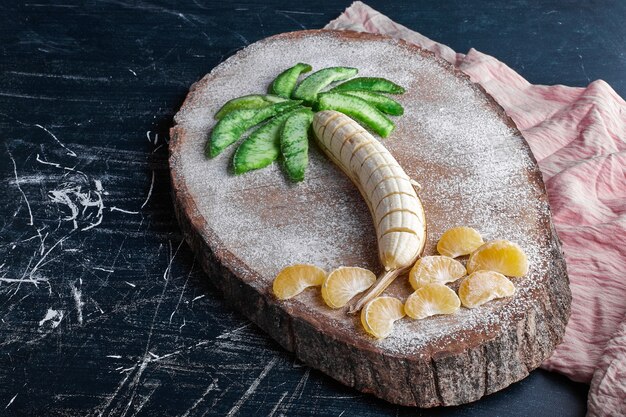 Plátano con mandarinas y rodajas de aguacate seco en forma de palmera.