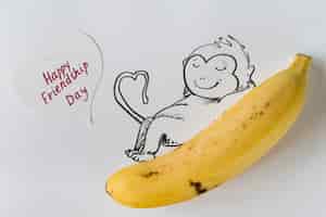 Foto gratuita plátano con mono pintado y tarjeta de felicitación.