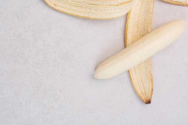 Plátano pelado solo en el cuadro blanco.