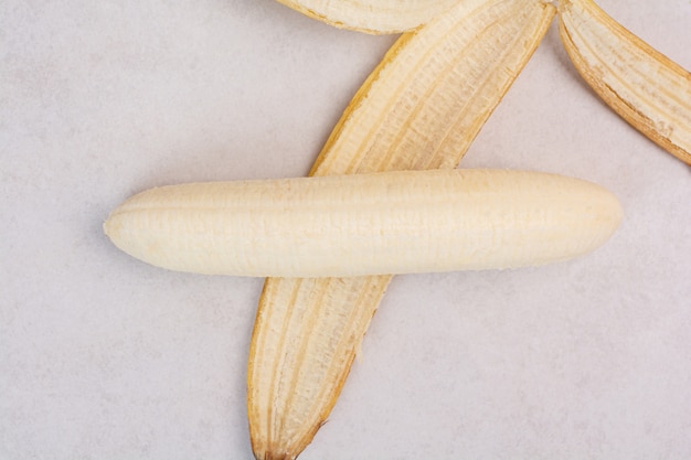 Foto gratuita plátano pelado solo sobre mesa blanca