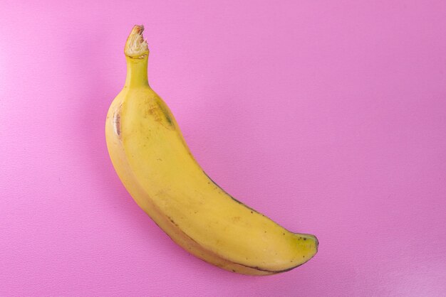 Plátano en la superficie rosa