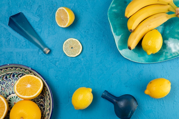 Plátanos y limones sobre fondo azul