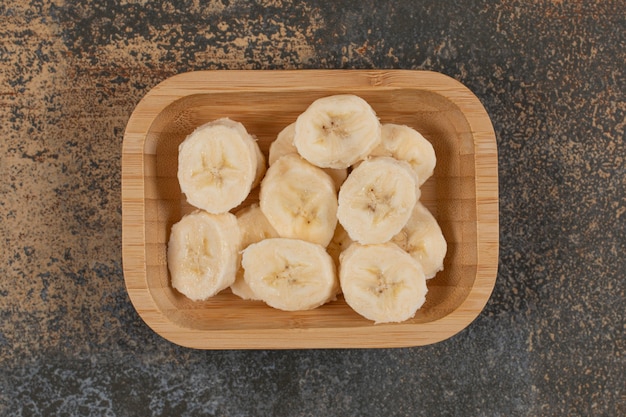 Foto gratuita plátanos pelados en rodajas sobre placa de madera