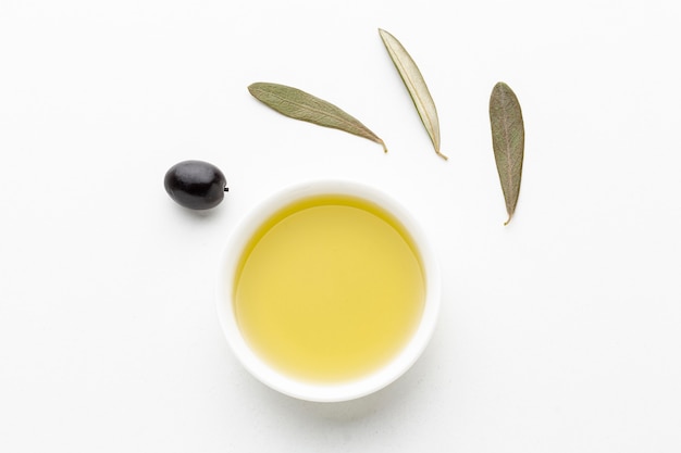 Platillo de aceite de oliva con hojas y aceituna negra