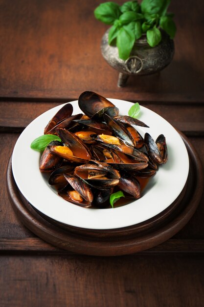 Plato de almejas cocinadas con hojas verdes