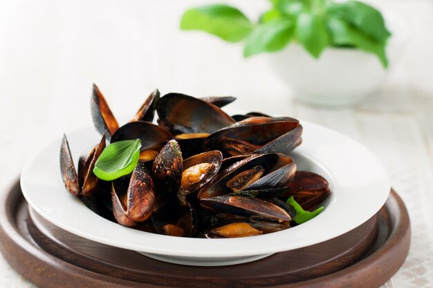 Plato de almejas cocinadas con hojas verdes