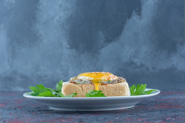 Un plato azul de deliciosas tostadas con huevo frito y hierbas.