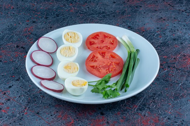 Un plato azul de huevos duros con verduras