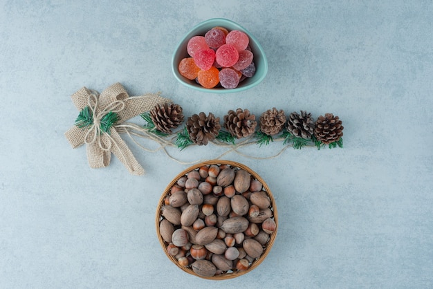 Un plato azul de mermelada con pequeñas piñas de Navidad sobre fondo de mármol. Foto de alta calidad