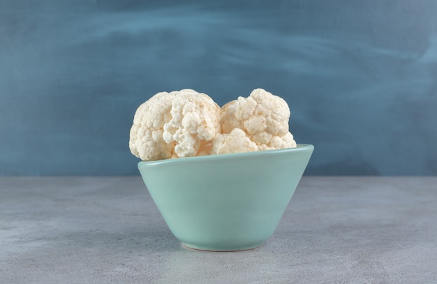 Un plato azul con vegetales de coliflor picados. Foto de alta calidad