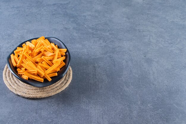 Un plato de batatas fritas en salvamanteles, sobre el fondo de mármol.