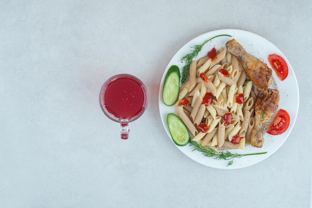 Un plato blanco con deliciosa pasta y verduras en rodajas.