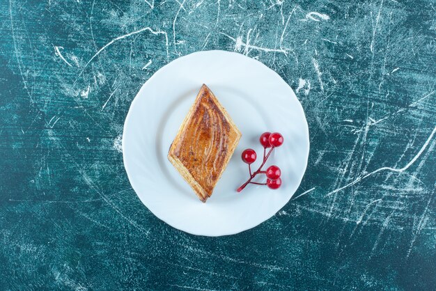 Un plato blanco de deliciosos pasteles dulces sobre un fondo azul. Foto de alta calidad