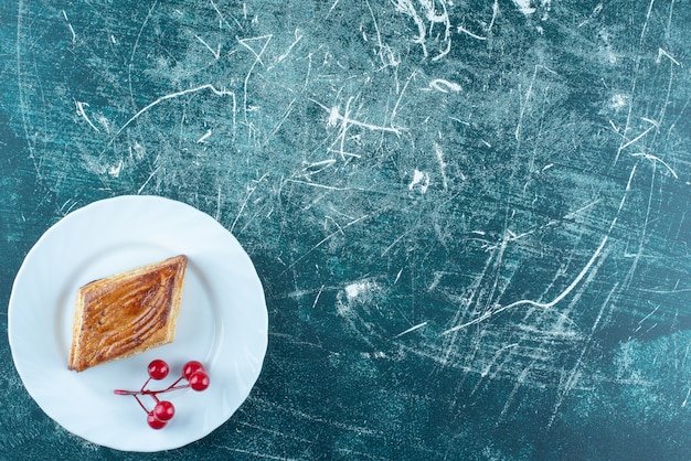 Un plato blanco de deliciosos pasteles dulces sobre un fondo azul. Foto de alta calidad