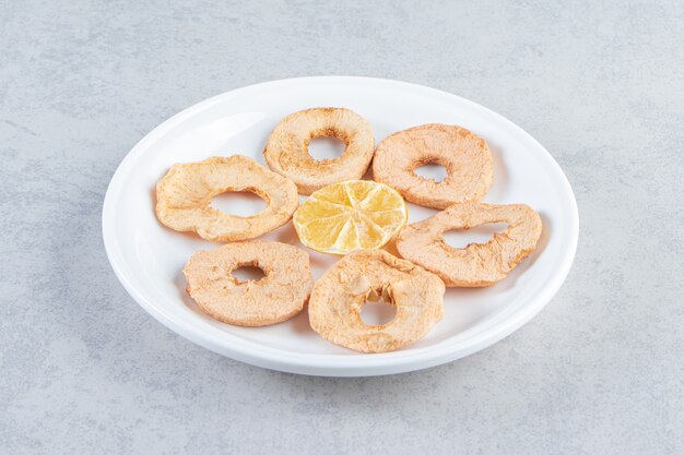 Un plato blanco con frutos secos saludables sobre fondo de mármol.