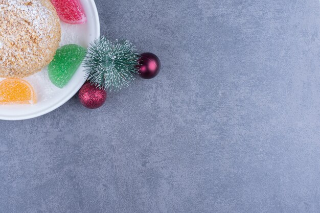 Un plato blanco con galletas y caramelos de gelatina azucarados.