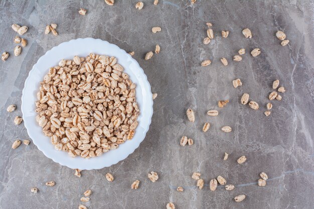 Un plato blanco lleno de cereal de desayuno de arroz crujiente.