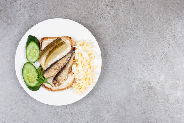 Un plato blanco con tostadas fritas y espadines.