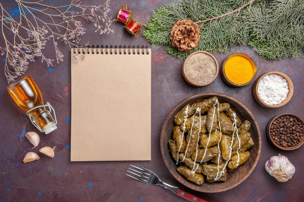 Plato de carne de dolma de hoja sabrosa vista superior con condimentos en el escritorio oscuro