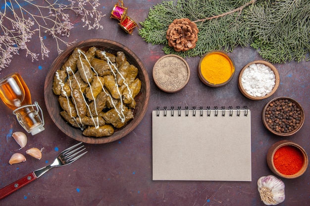 Plato de carne de dolma de hoja sabrosa vista superior con condimentos en la oscuridad