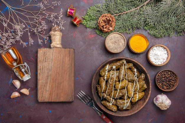 Plato de carne de dolma de hoja sabrosa vista superior con condimentos en la oscuridad