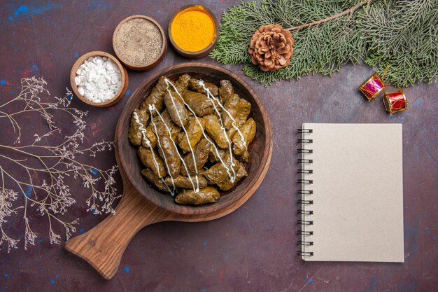 Plato de carne de dolma de hoja sabrosa vista superior con condimentos en la oscuridad