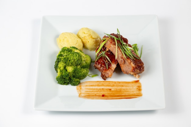 Plato de carne con puré de patatas con salsa barbacoa y brócoli