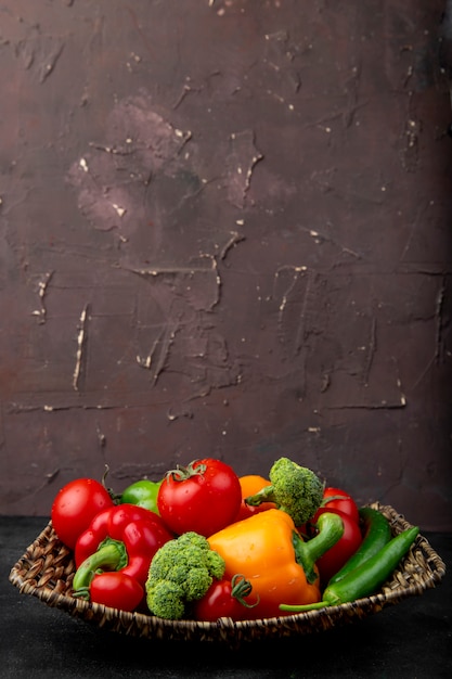 Foto gratuita plato de cesta lleno de verduras sobre superficie negra