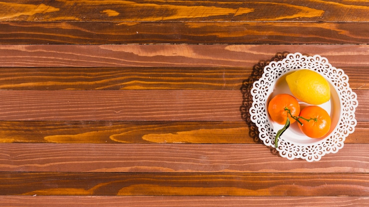 Foto gratuito plato con cítricos en mesa de madera.