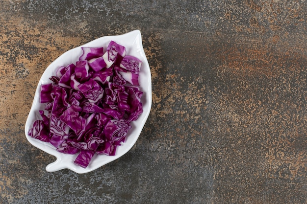 Plato de col roja en forma de hoja, sobre la superficie de mármol