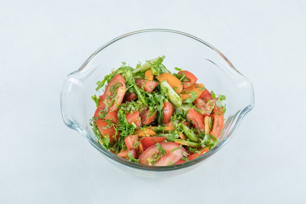Un plato de cristal de deliciosa ensalada de verduras.