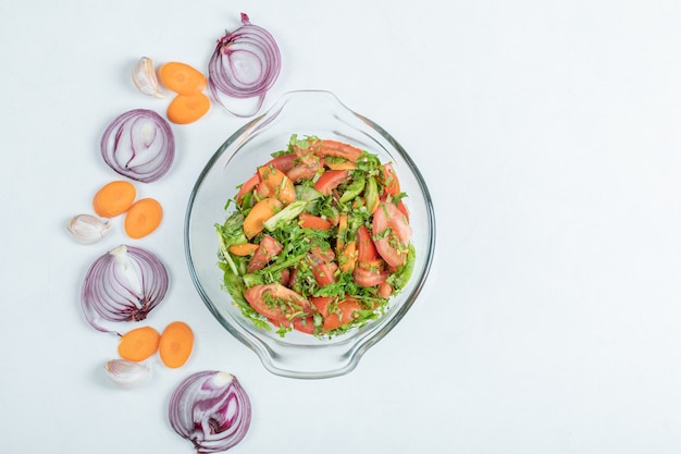 Un plato de cristal de deliciosa ensalada de verduras.